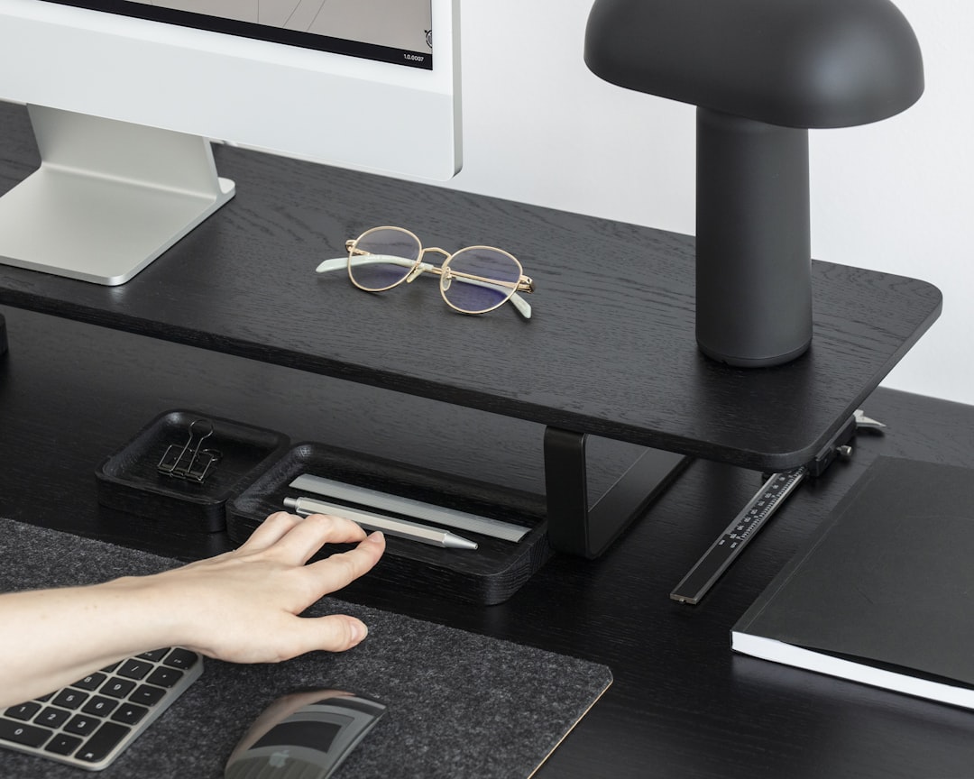Sleek, modern compass rests on a bright, uncluttered desk next to a laptop, symbolizing strategic direction and navigating...